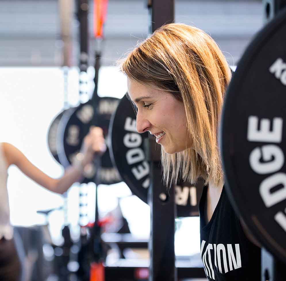 Woman lifting large weight at the Cinch Training Gym
