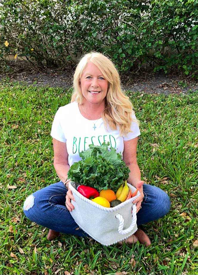 Diane powell sitting outdoors with a basket full of vegetables