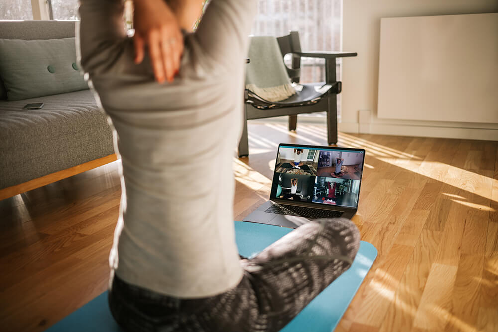 woman watching online fitness class in living room