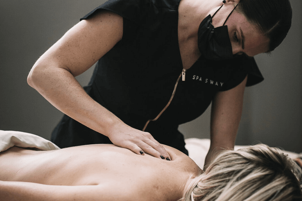 woman getting a sports massage at spa sway in austin texas