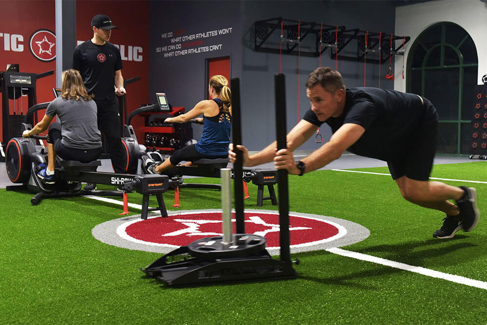 weighted sled sprint and row machine workout at athletic public