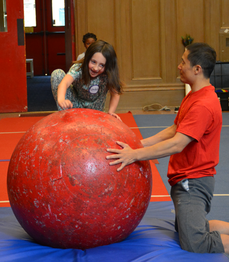 Students joyfully struggles to climb on to the rolla bolla with the teachers' assistance | Circus Center | San Francisco