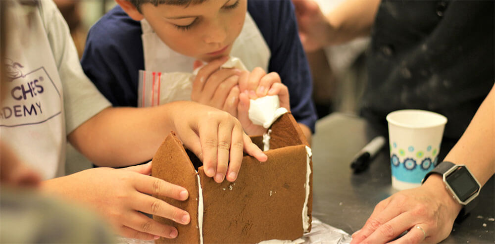 kids making a ginger bread house at young chefs academy