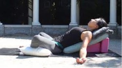 Pregnant woman doing supta baddha konasana yoga pose at cocoon care