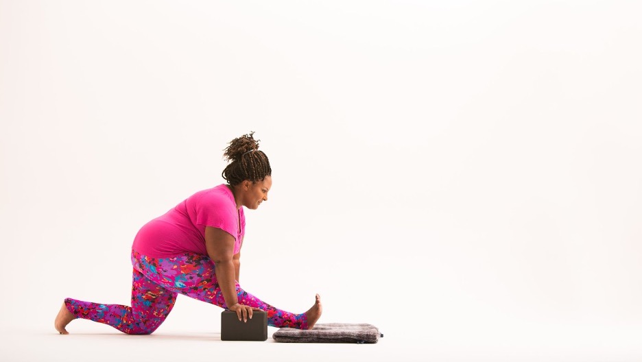 postpartum woman doing a half split yoga pose at cocoon care