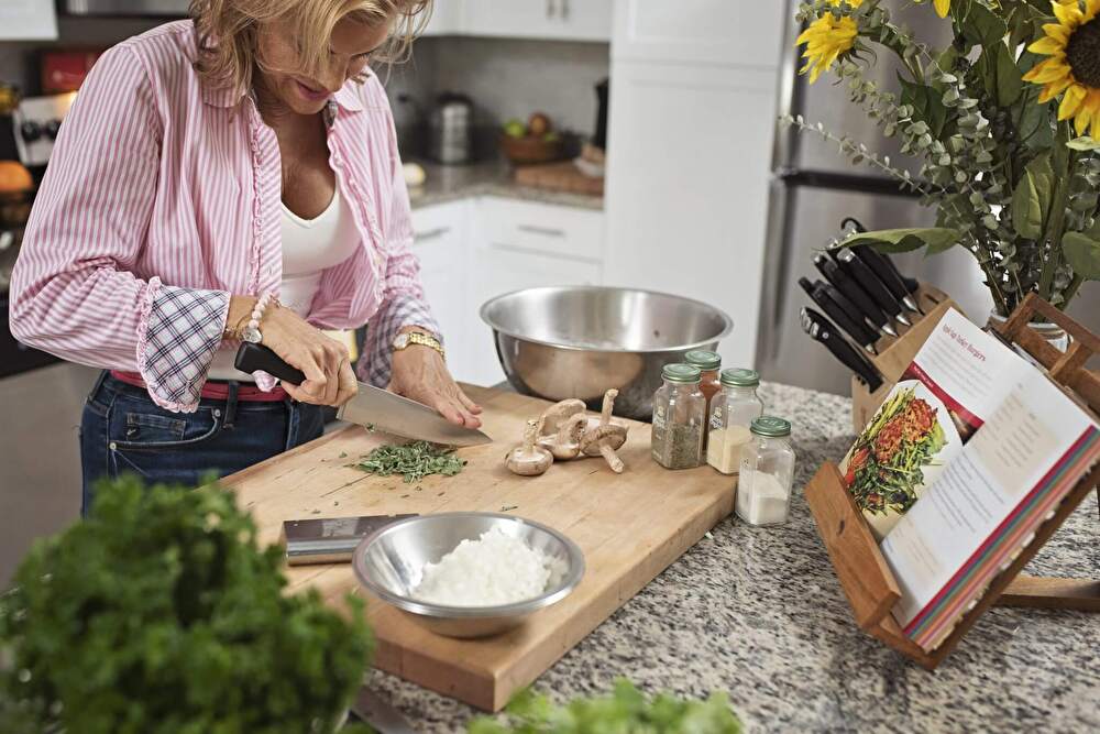 woman-cutting-veggies-cookbook