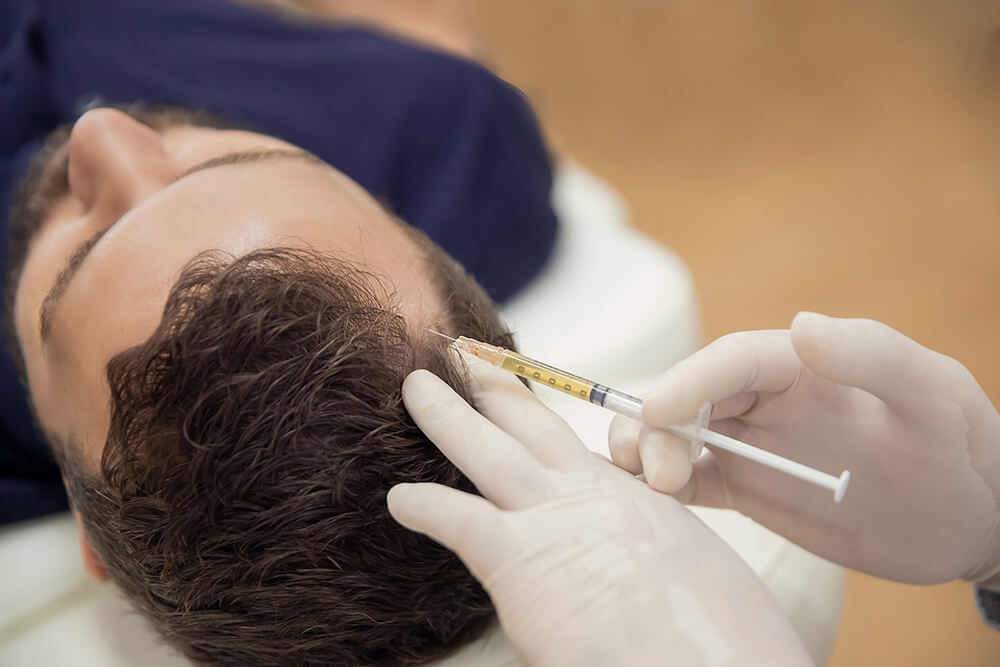 injecting hair growth into man's scalp
