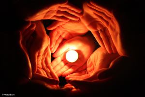candle_surrounded_with_many_hands-other