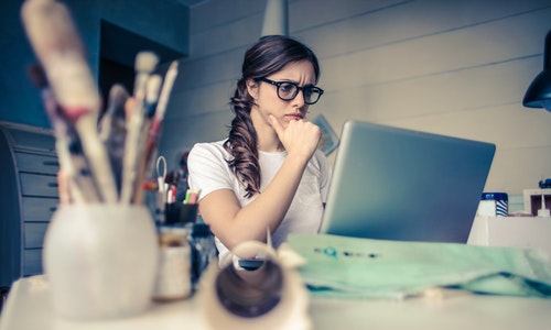 businesswoman sitting at her computer looking stressed out