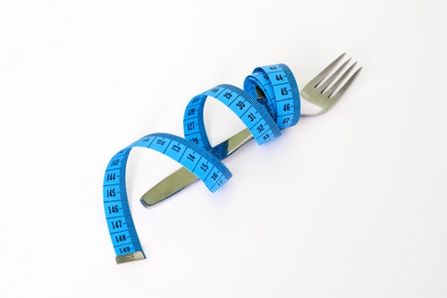 measuring tape with fork - dieting -intermittent fasting - health