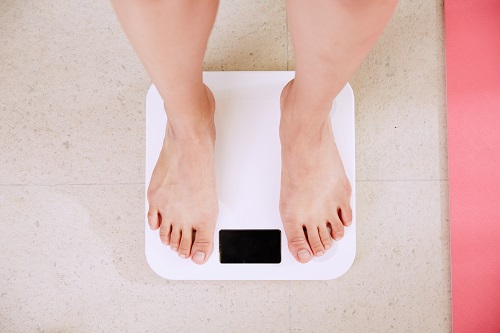 personal standing on a digital scale looking for weight loss