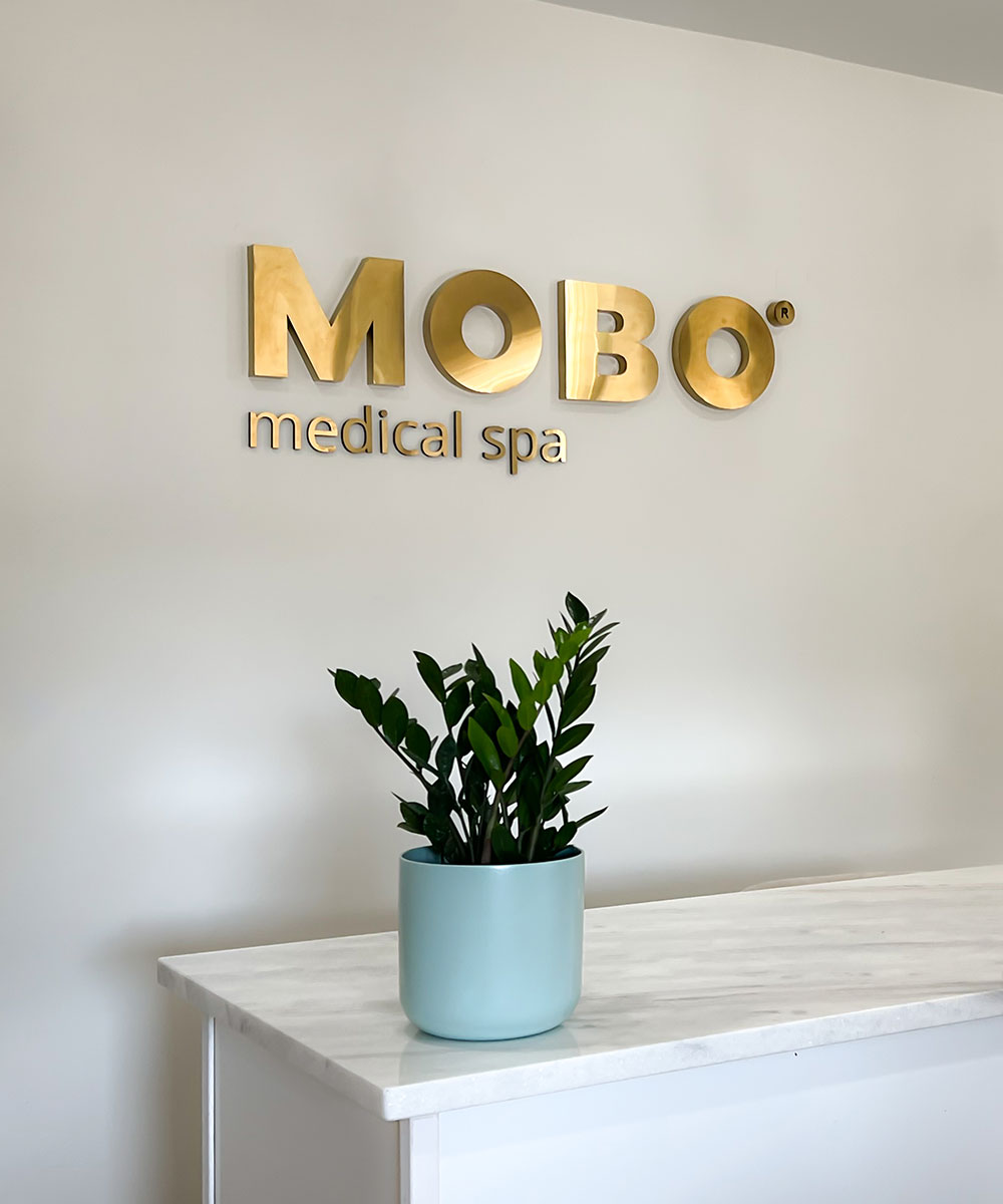 mobo sign on walk with plant on desk