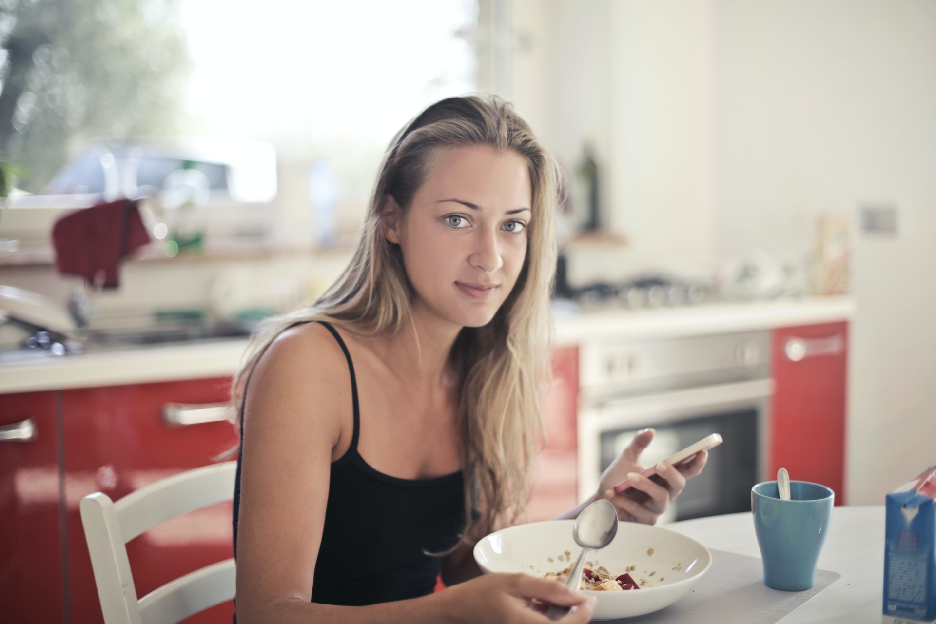 woman breakfast spoon smartphone