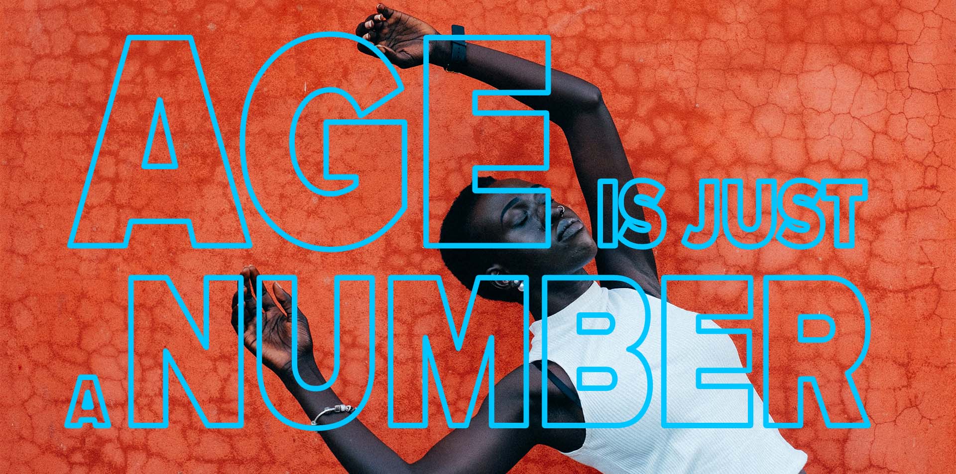 A confident adult Hip Hop dancer lying against a vibrant orange background, symbolizing energy, creativity, and the idea that age is just a number in Calgary's dance community.