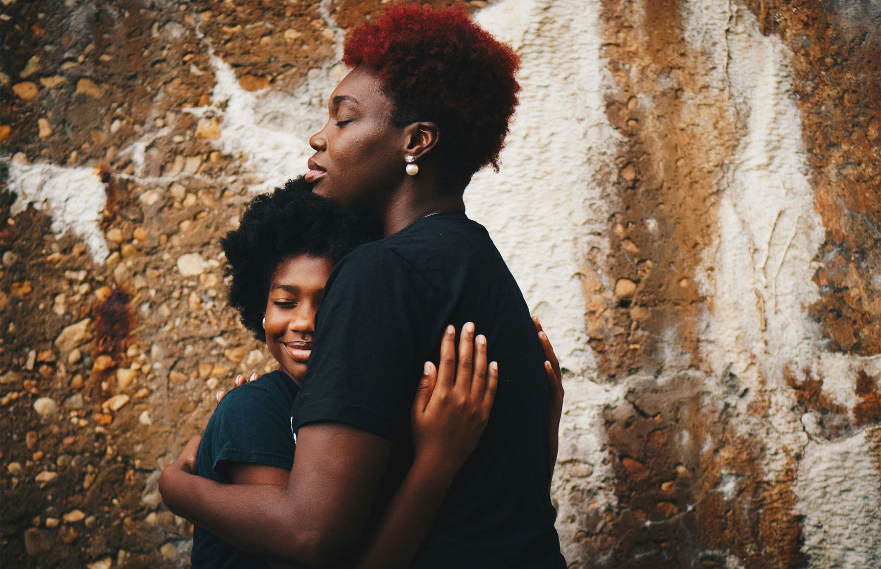 A parent embraces their child with a loving hug, symbolizing the emotional support parents provide to young dancers in dance studios.