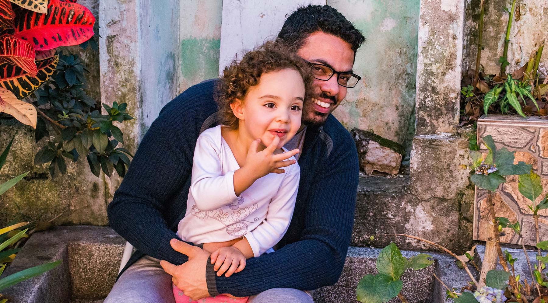 A smiling parent holding their child close, representing the important role of parents in supporting young dancers as they progress in dance classes.