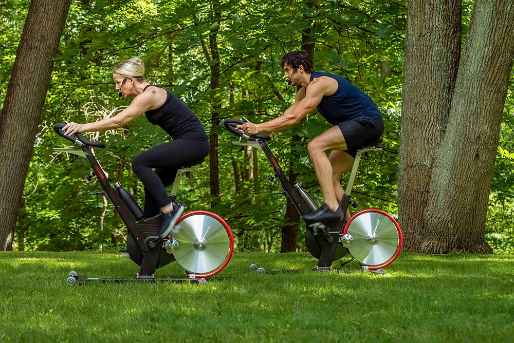 two people in an outdoor cycling class at ride + reflect