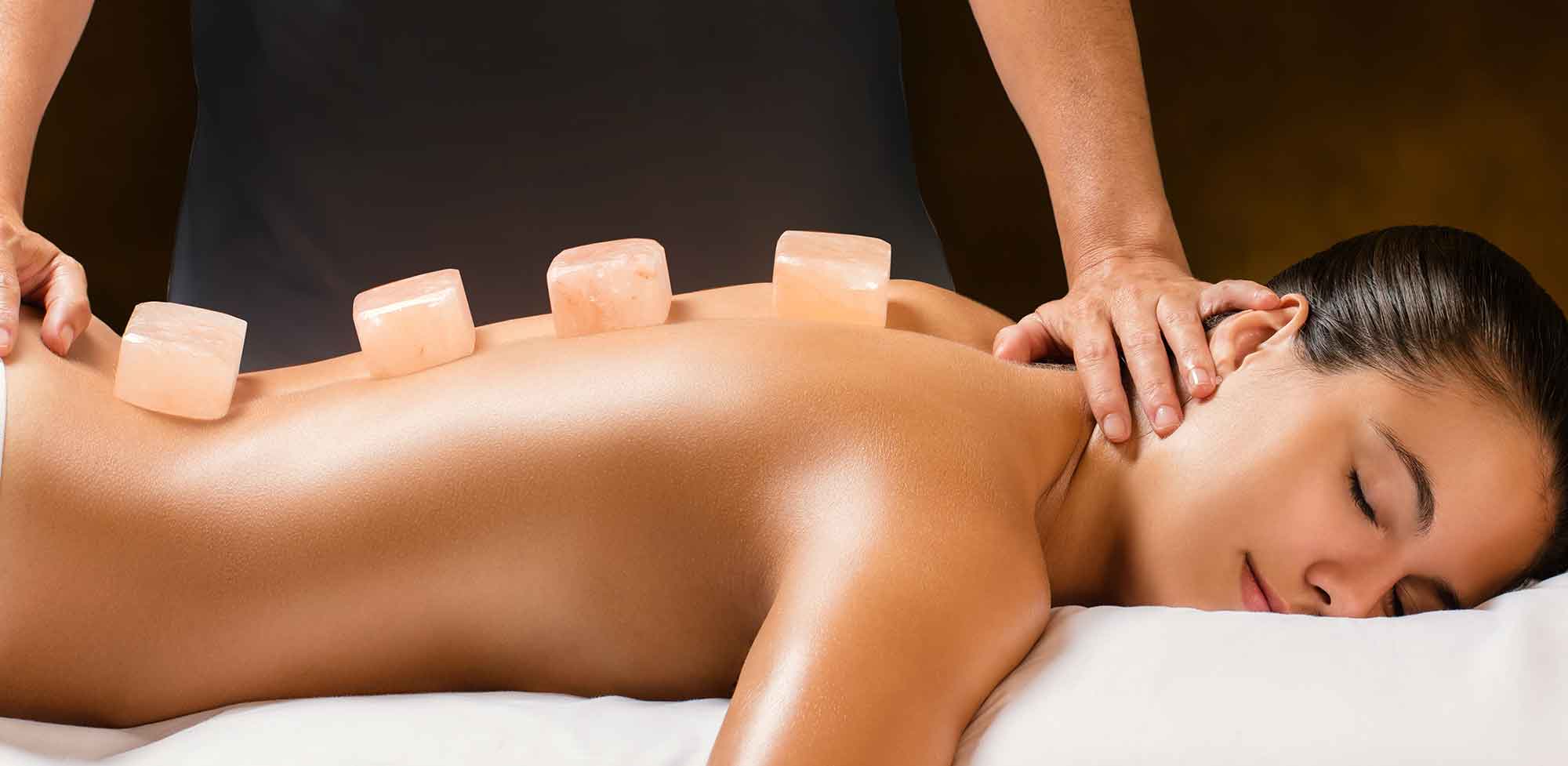 himalayan salt stones on a woman's back