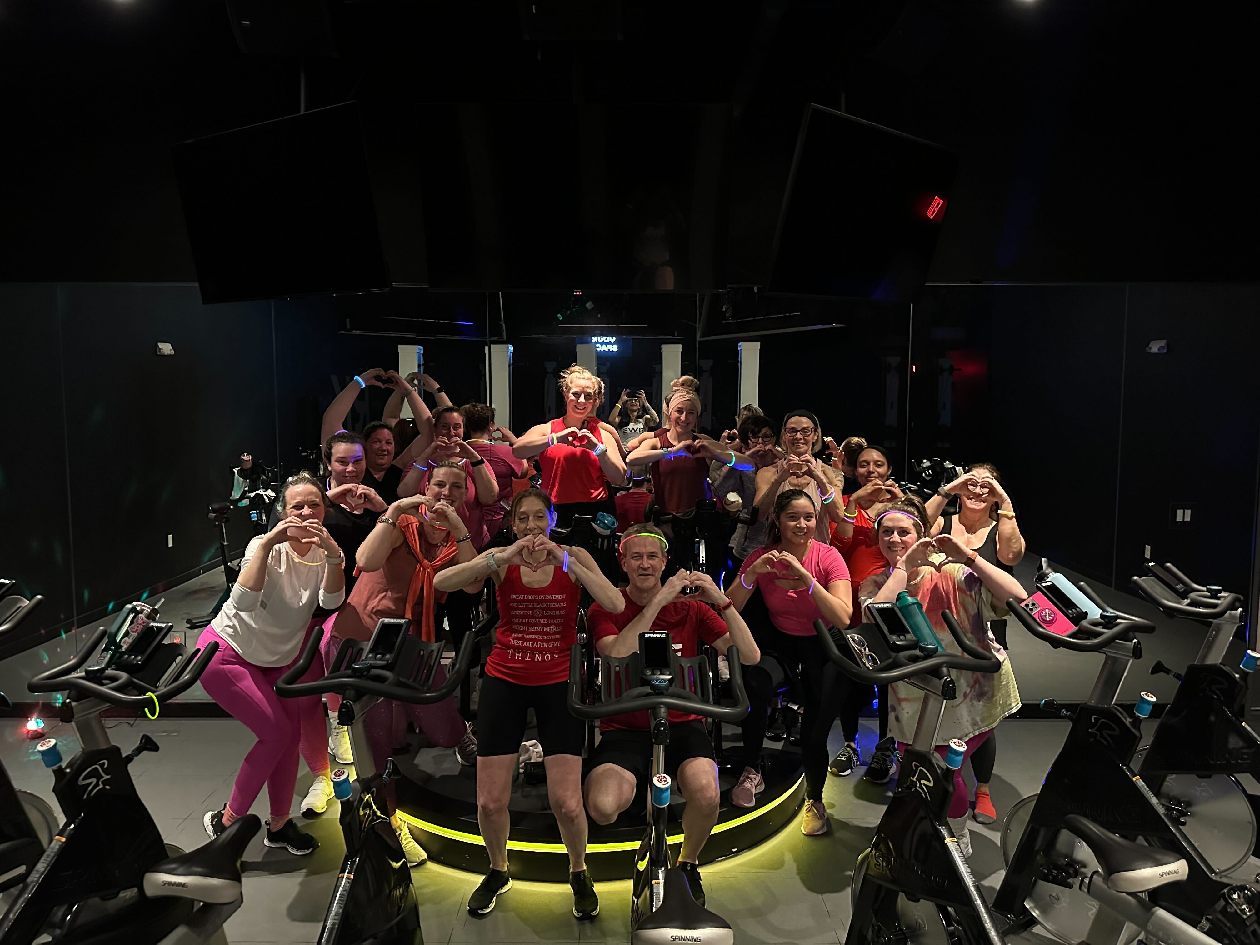 Spenga Spin Members on bikes making hearts with hands
