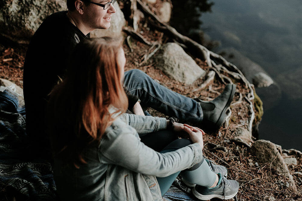 couple-sitting-edge-mountain