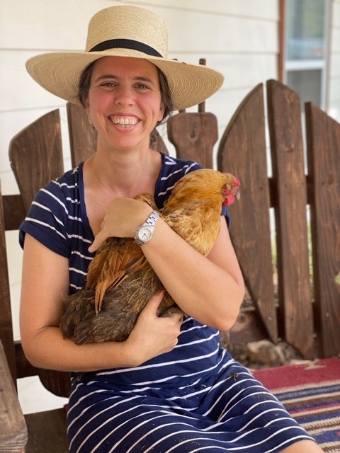 a smiling woman holding her chicken