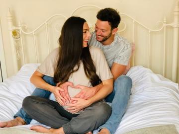 Man holding wife's belly at Yoga Bumps & Babies