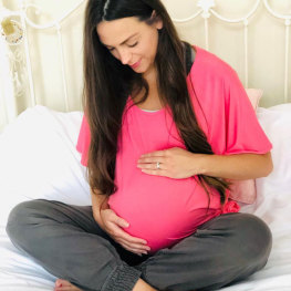 woman holding baby bump at Yoga Bumps & Babies